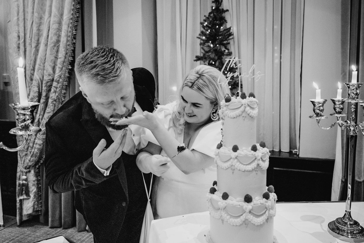 Wedding reception celebration with guests dancing and a traditional white tiered cake. Wedding photographer dublin