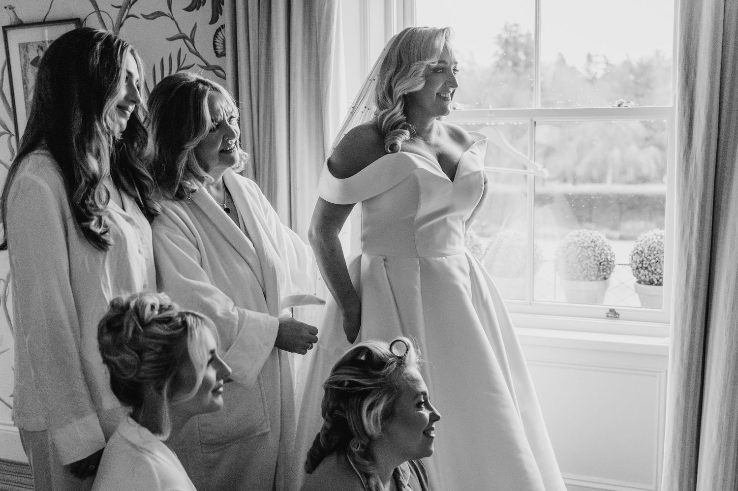 Natural window light illuminates a preparation scene with someone in white getting ready. Virginia Park Lodge Wedding Photographer Dublin Me