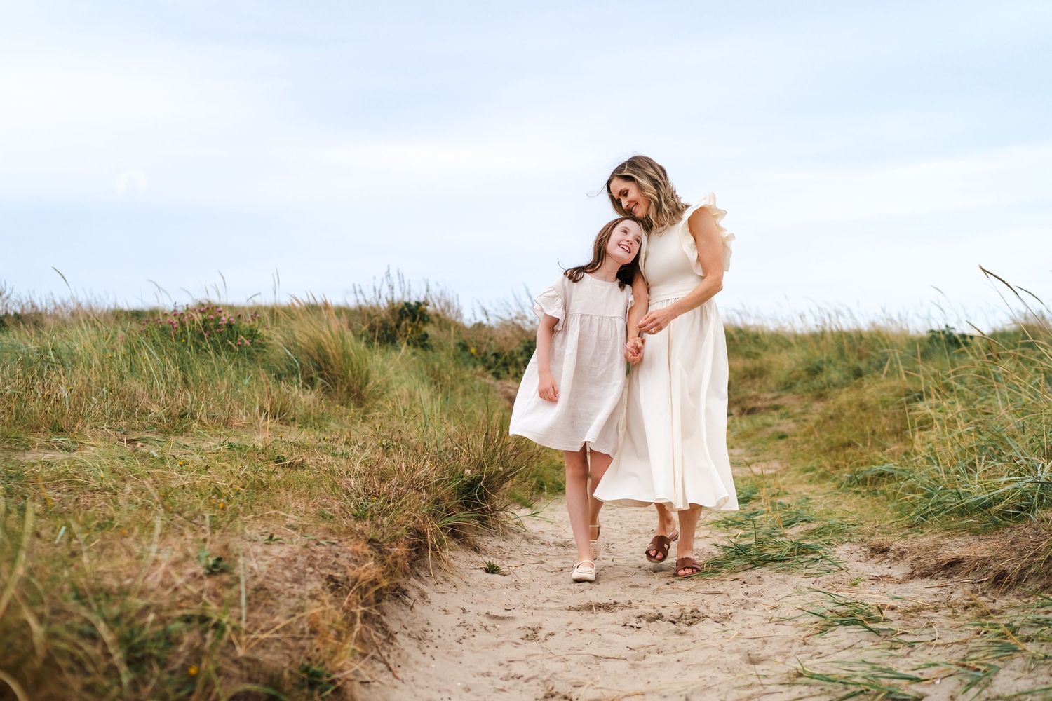 Candid lifestyle photos at the beach with sand dunes and natural coastal vegetation.  Family photographer Dublin Ireland