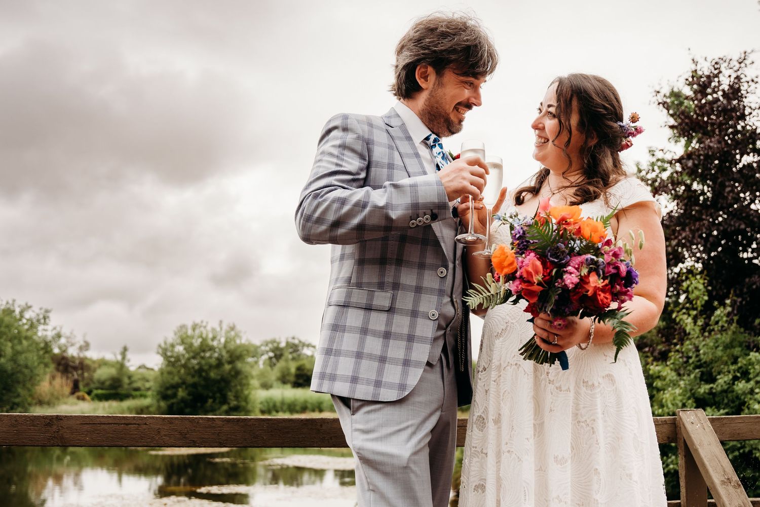 Newlyweds share an intimate moment on a bridge with colorful autumn bouquet. Wedding photographer Dublin
