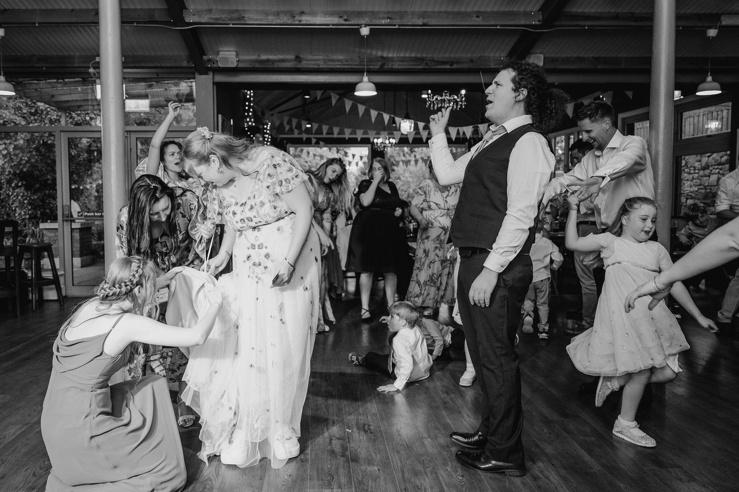 A lively dance floor scene at a wedding reception with guests dancing and celebrating in black and white. wedding photographer dublin