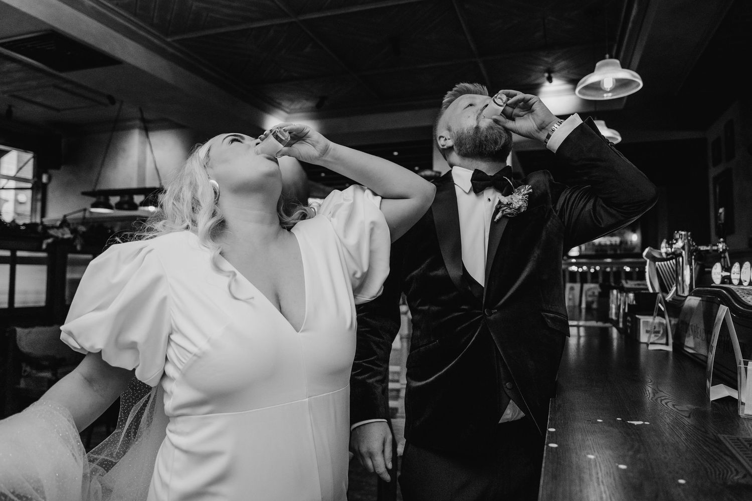 Wedding couple takes celebratory shots together at a dark bar. City Hall Dublin Photographer
