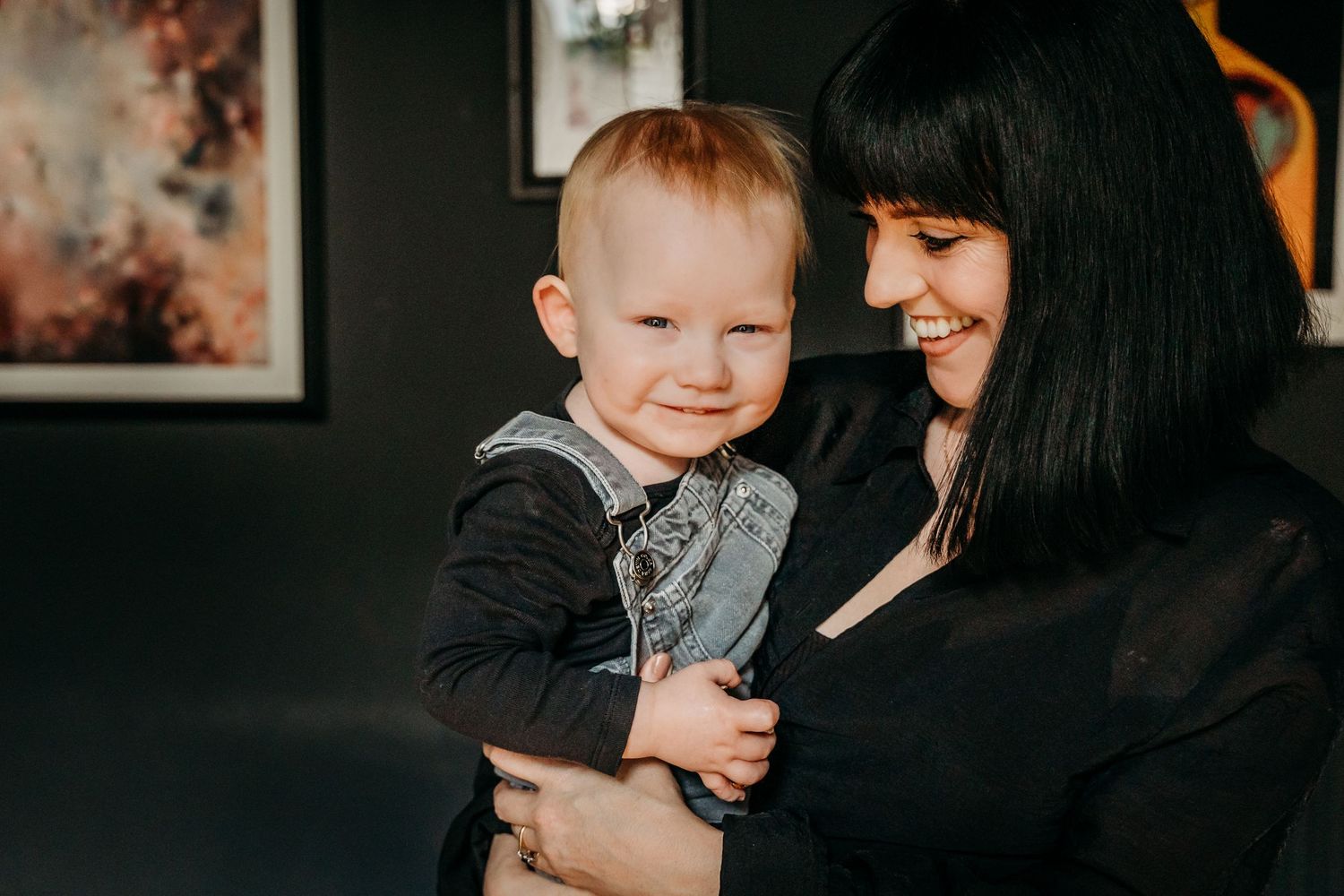 A tender moment showing a close connection between a toddler and who appears to be a parent in a dark setting.  Family PHOTOGRAPHER Dublin