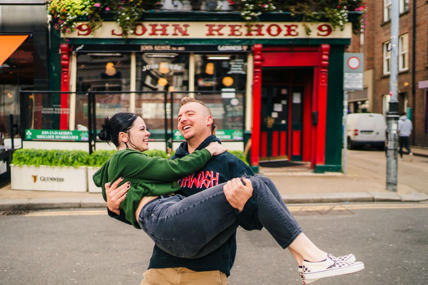 A playful moment outside a shop as one person carries another in their arms. PHOTOGRAPHER Dublin Ireland
