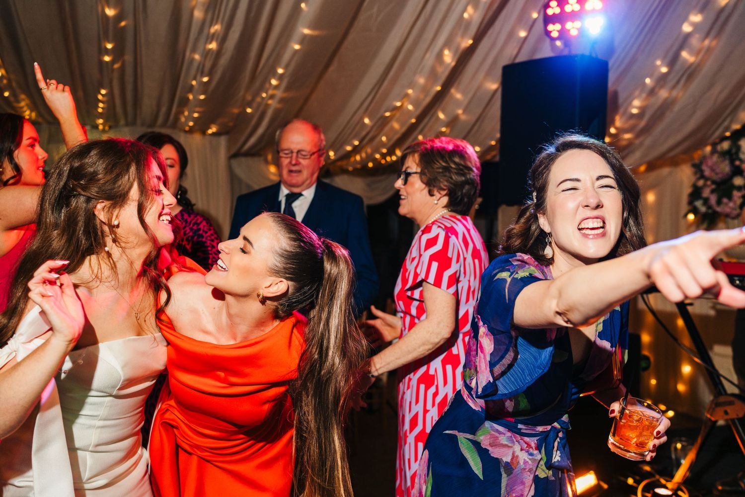 Castle Leslie Wedding Photographer Dublin Wedding reception guests dancing enthusiastically under festive lighting.