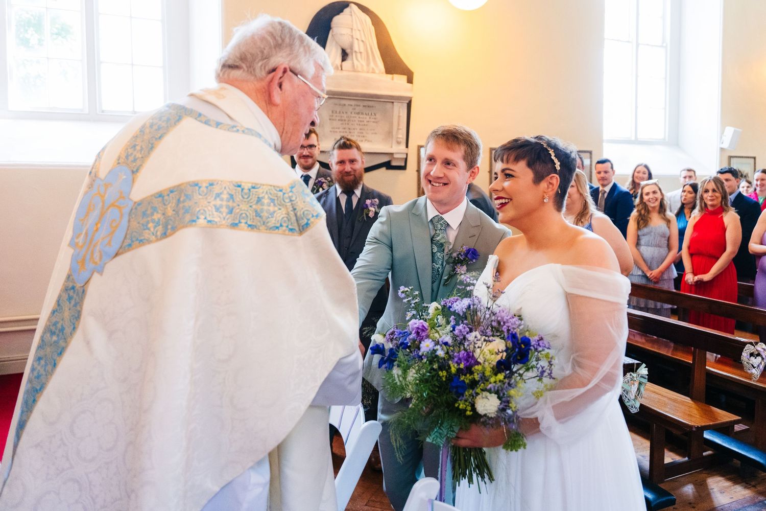 Millhouse slane wedding photographer dublin Guests gathered in traditional church pews during a joyful wedding ceremony.