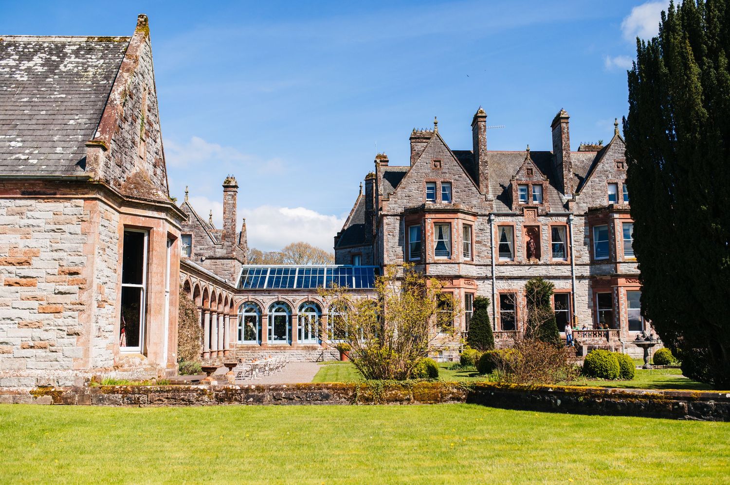 Castle Leslie Wedding Photographer Dublin Historic stone mansion with Victorian architecture featuring solar panels on a sunny day.