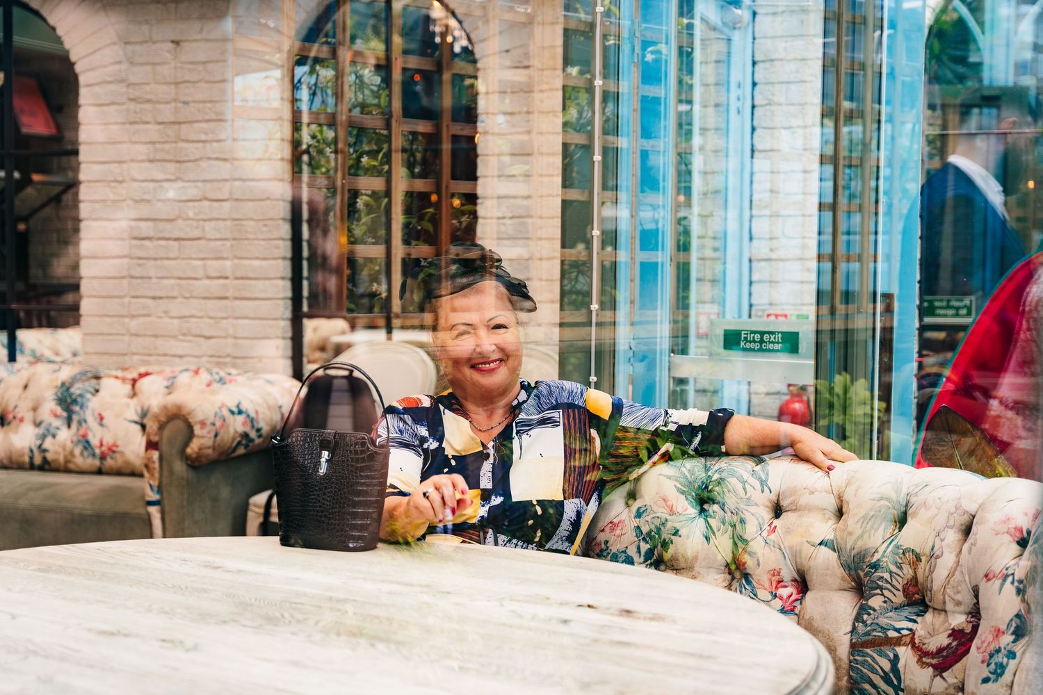 A guest sits at a vintage floral couch with drinks at an elegant venue. House Dublin Wedding Photographer