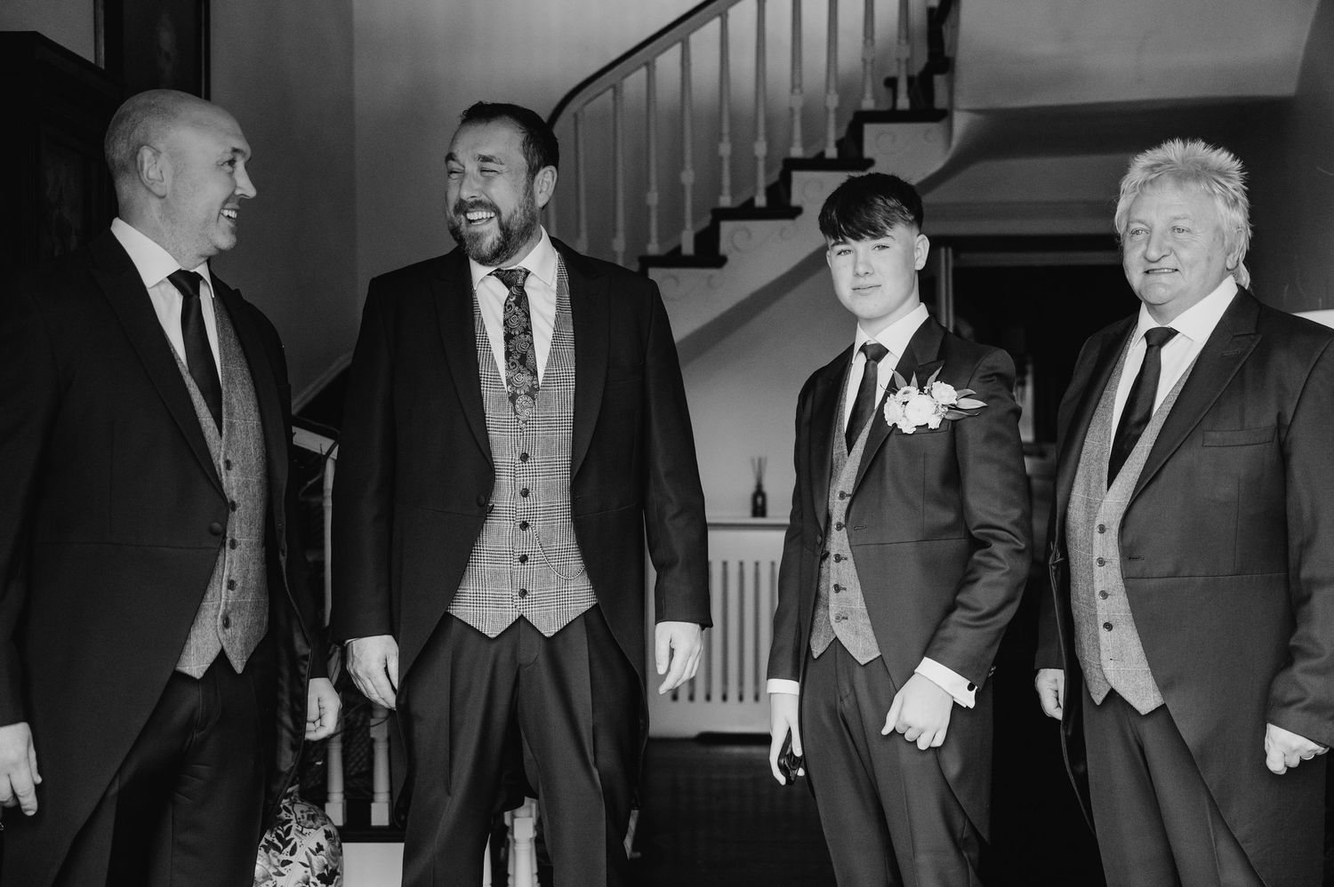Wedding party members share a candid laughing moment in black and white photography during formal portraits. Virginia Park Lodge Wedding Pho