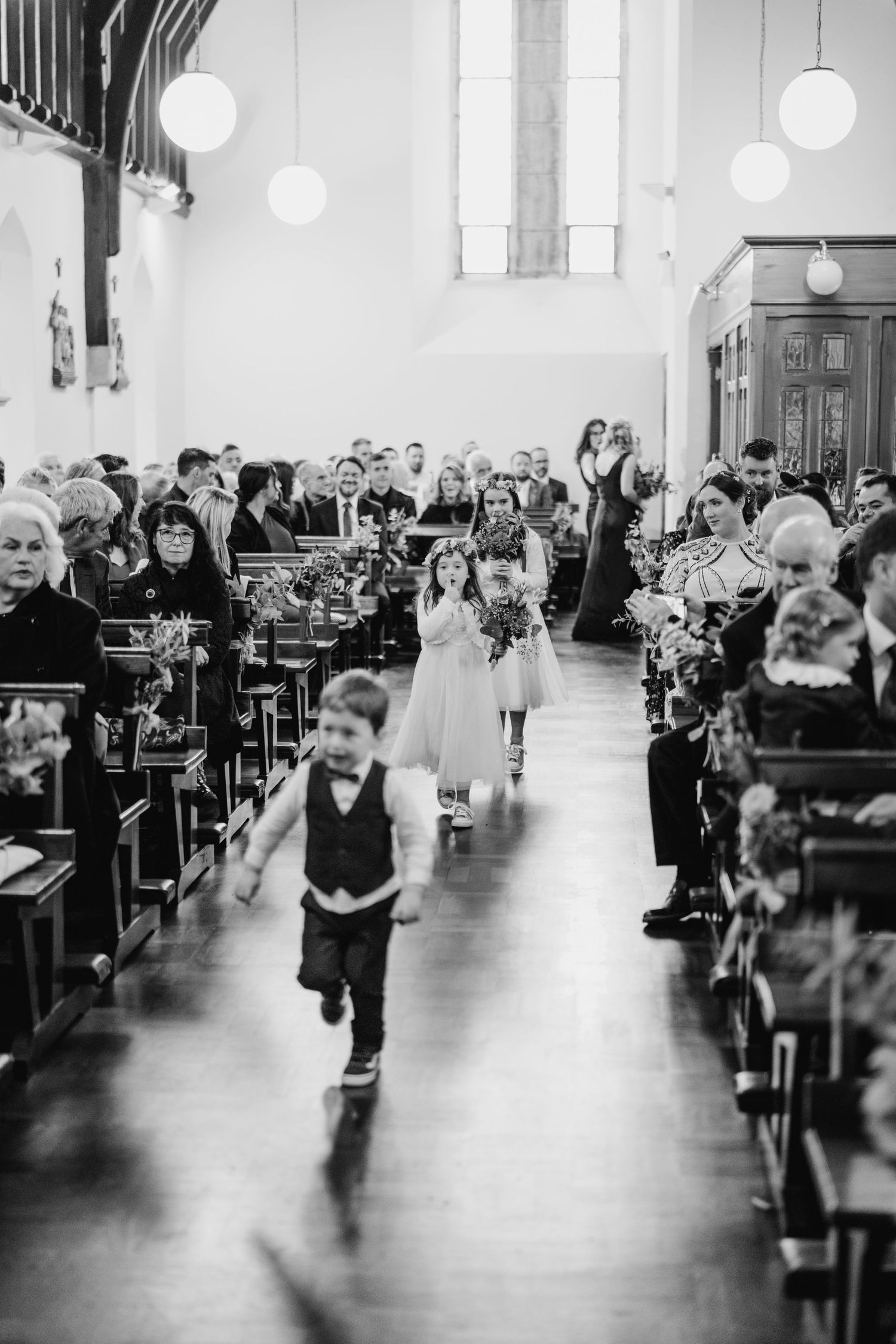Black and white photos showing a church aisle sequence during a wedding ceremony.