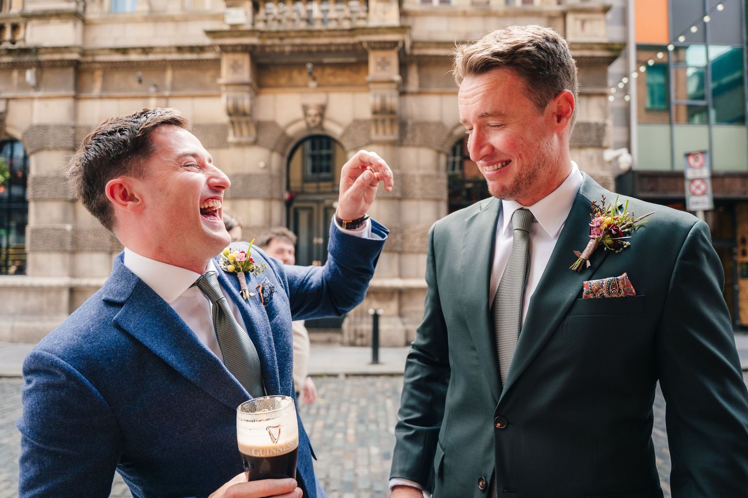 Groomsmen share jokes and laughter outside a historic stone building. Wedding photographer dublin