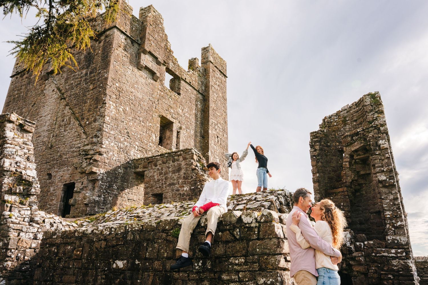 Historic stone castle ruins create a stunning backdrop for a joyful outdoor photoshoot. BEctive abbey family photographer dublin