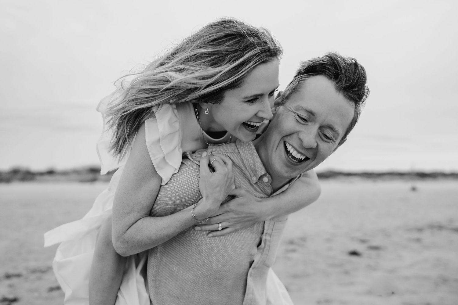 A happy couple shares playful and romantic moments while enjoying time together at the beach. Couple's photographer Dublin Ireland