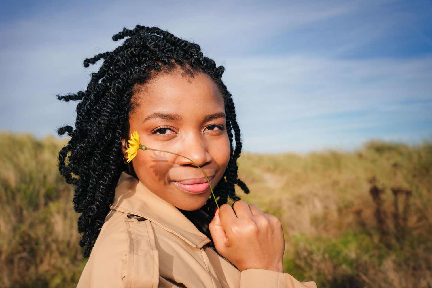 Natural outdoor portrait series with tan coat against coastal landscape backdrop. Dublin professional headshots photographer