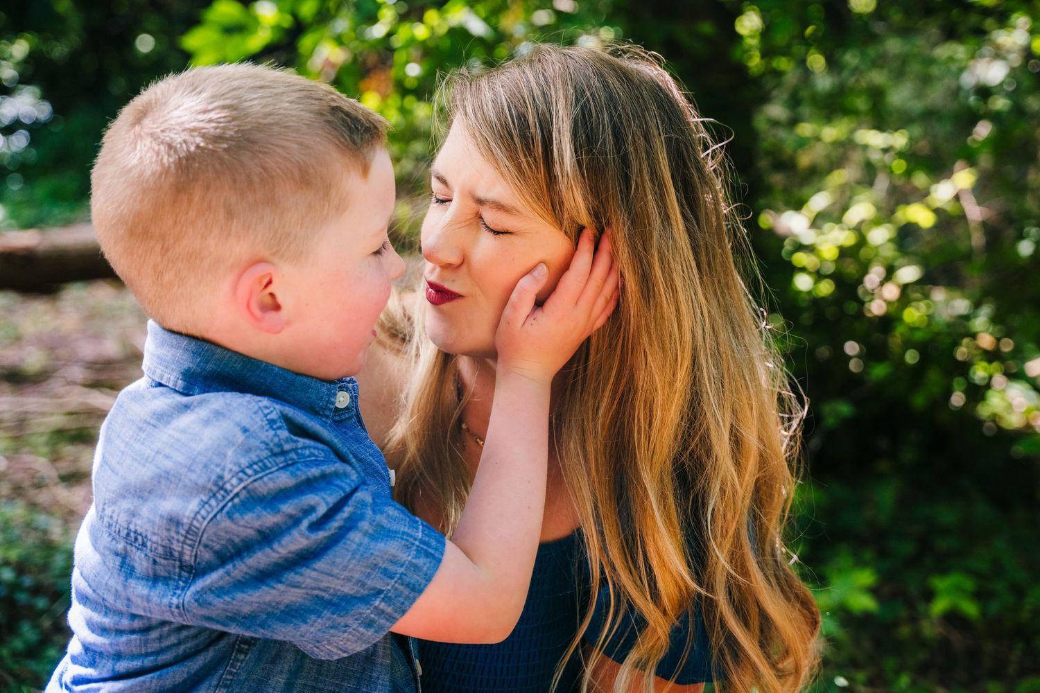 Intimate parent and child moment shared outdoors in natural lighting with greenery in background. family PHOTOGRAPHER Dublin
