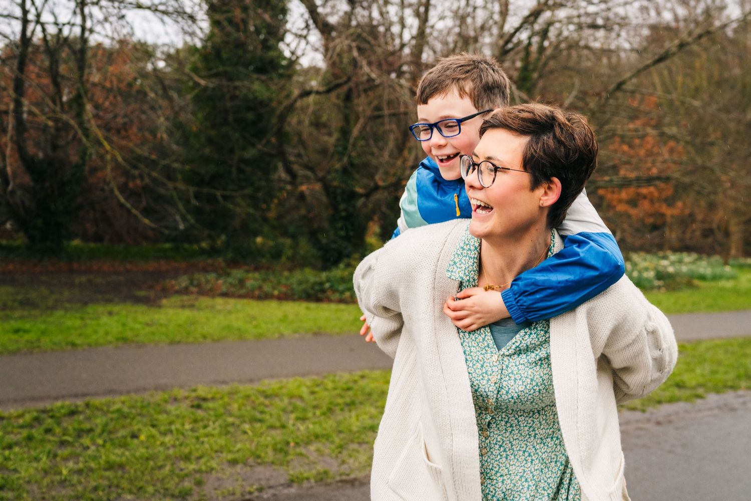 Family photographer Dublin Ireland  A playful piggyback ride moment captured on a park path.
