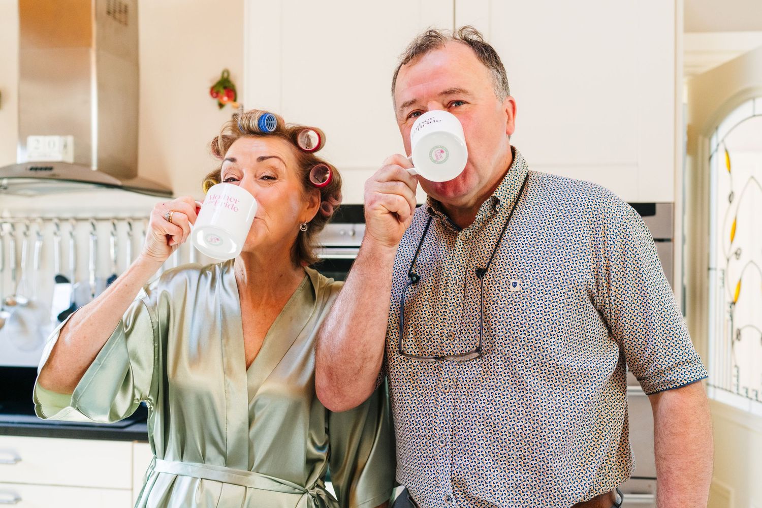 Castle Leslie Wedding Photographer Dublin A pair of people enjoy cups of coffee together in a cozy kitchen setting.
