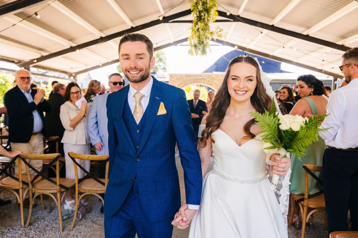 Poulaphouca Wedding photographer wicklow  Newlyweds celebrate during their outdoor wedding reception under a covered venue.