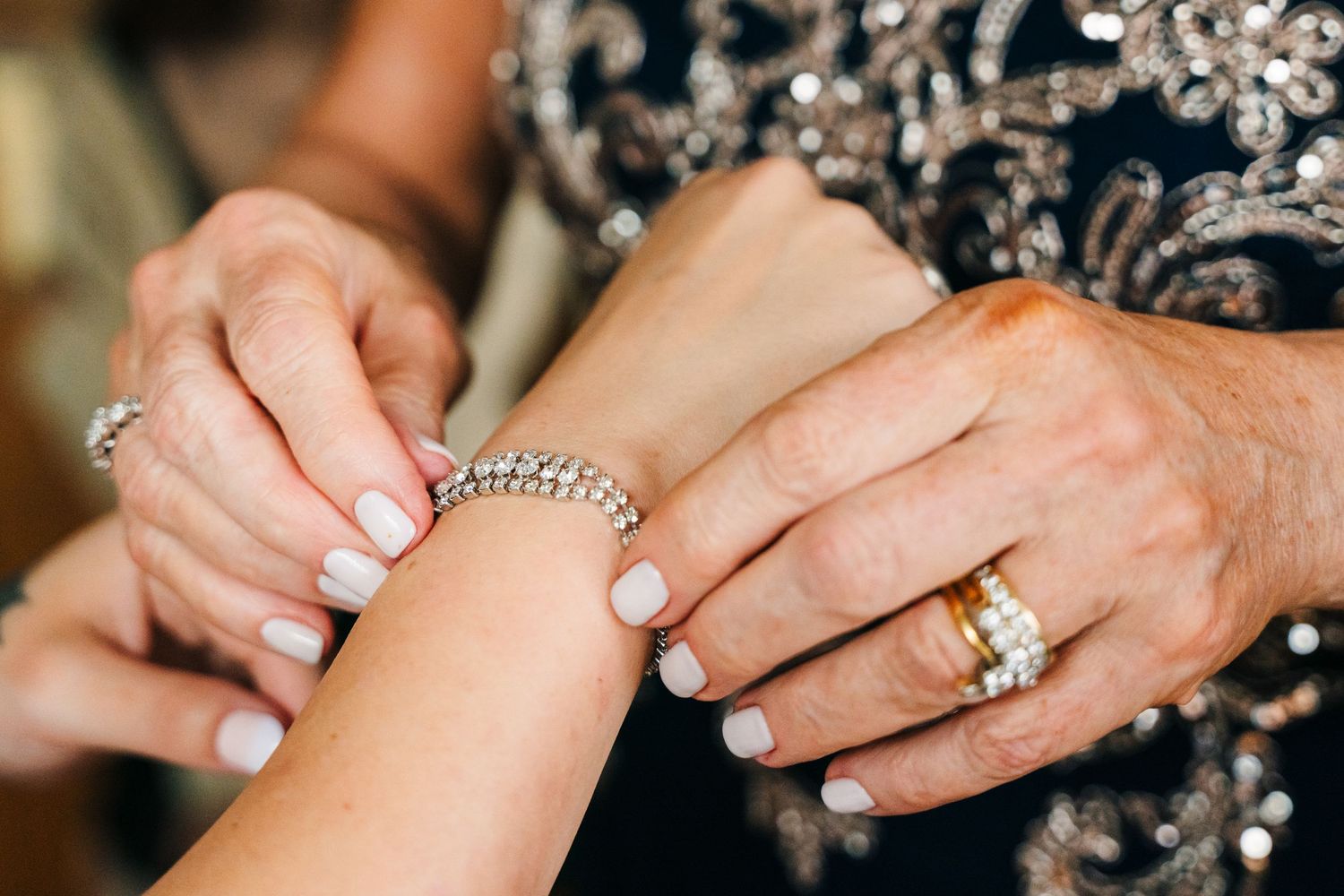 Close-up of hands showing elegant wedding ring and bracelet with white manicured nails.PHOTOGRAPHER Dublin Ireland Wedding