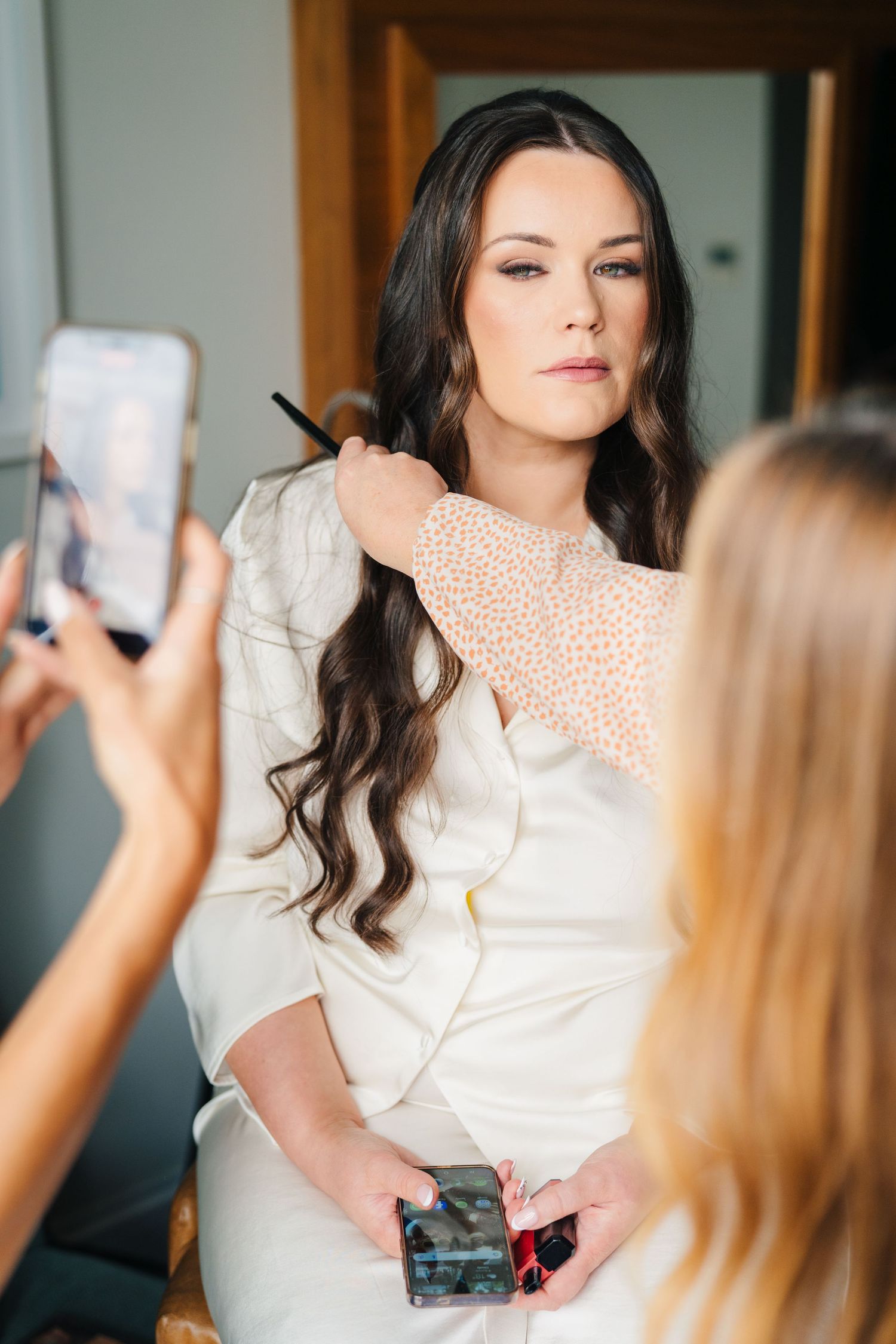 Getting ready photos as stylist adjusts wedding dress details. Portmarnock Hotel Wedding PHOTOGRAPHER Dublin