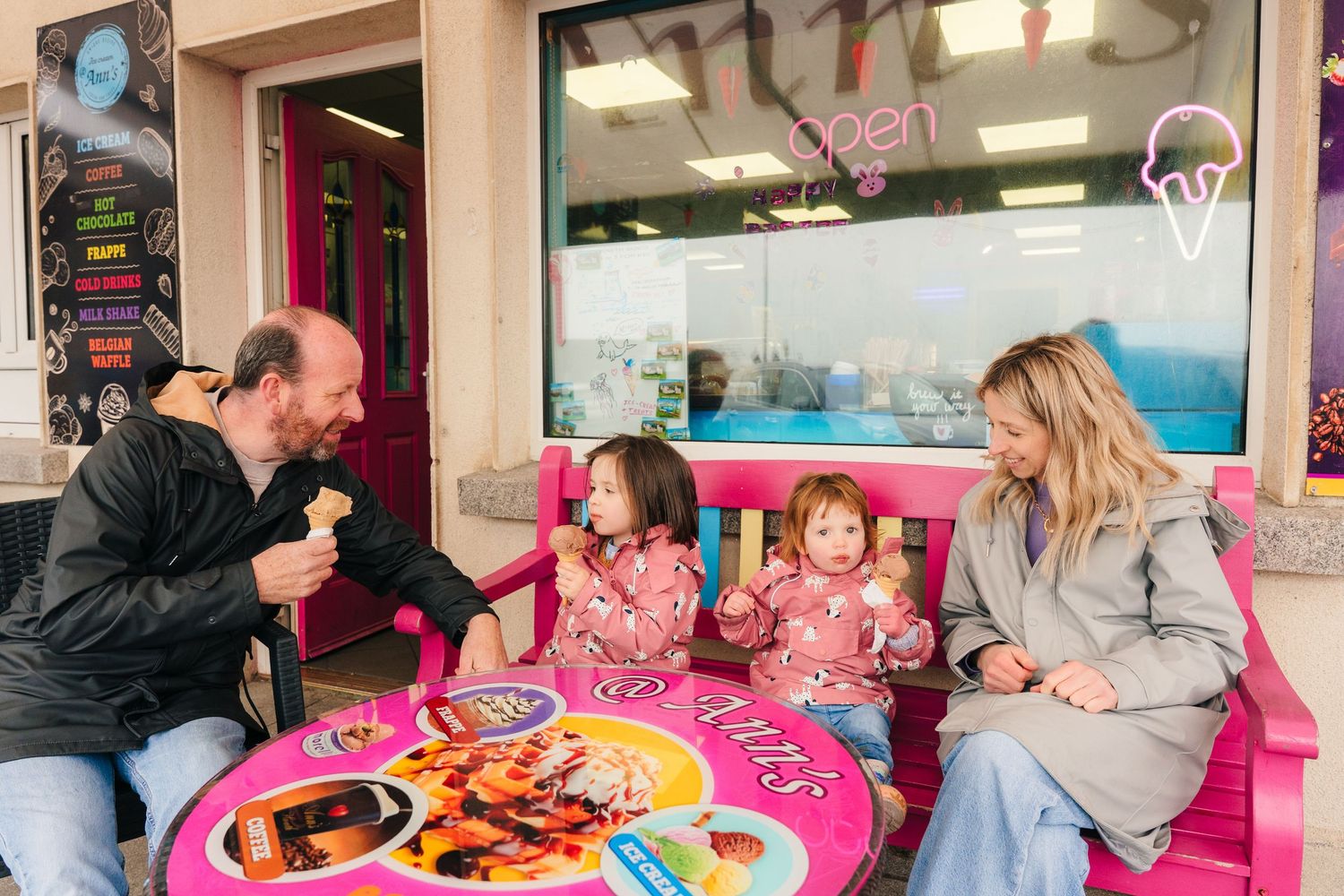 Family enjoying treats together at a pink-themed ice cream shop booth. PHOTOGRAPHER Dublin