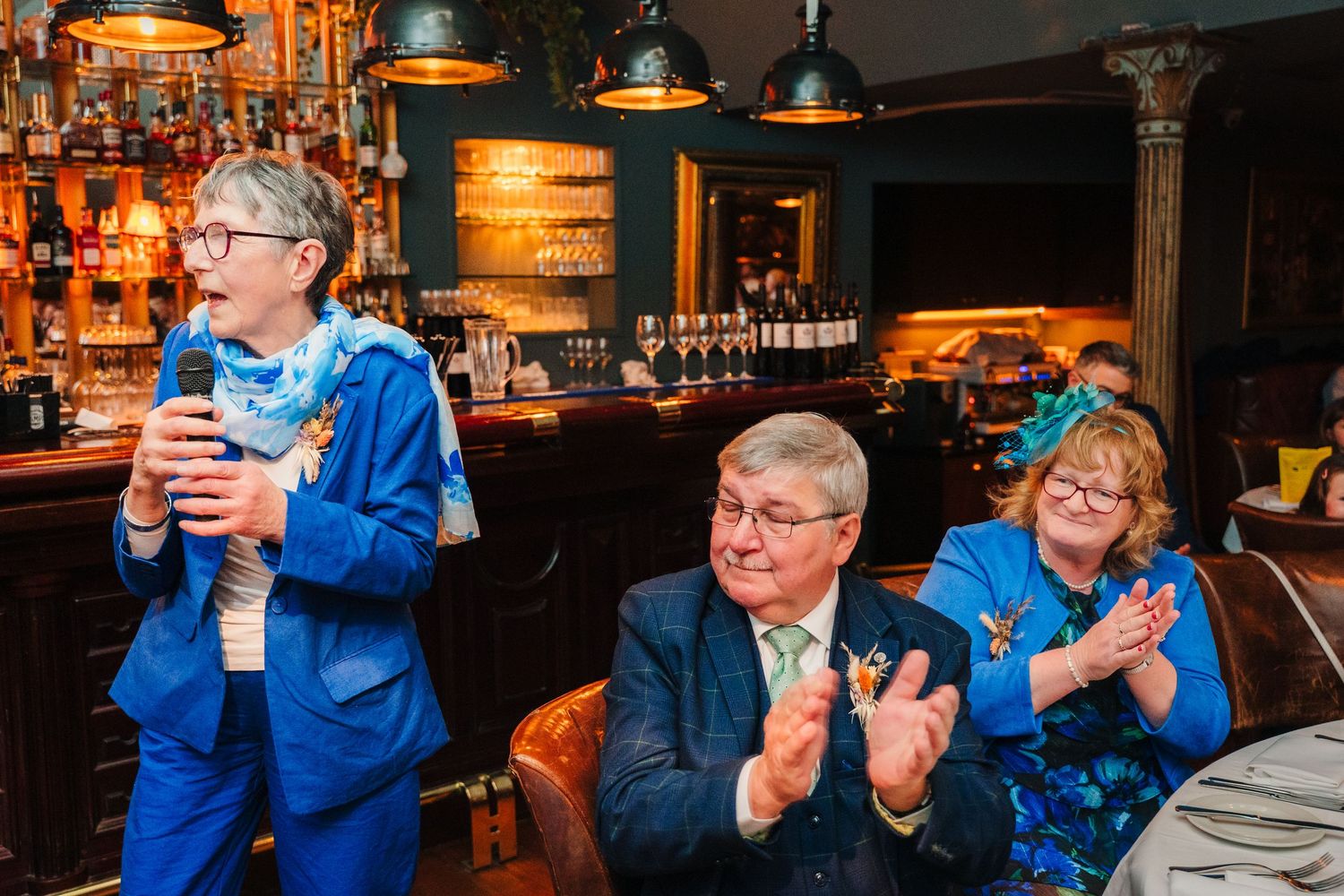 Guests sharing animated conversations at a bar with warm ambient lighting. Marco Pierre Dublin Wedding Photographer