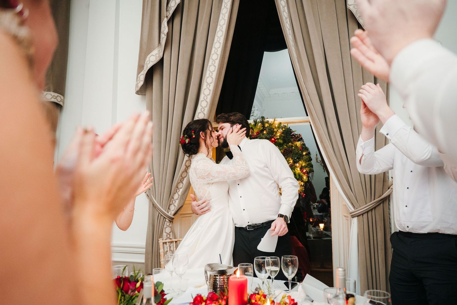 Wedding party celebrating with animated expressions and gestures during indoor reception. Stephens green club dublin Wedding photographer