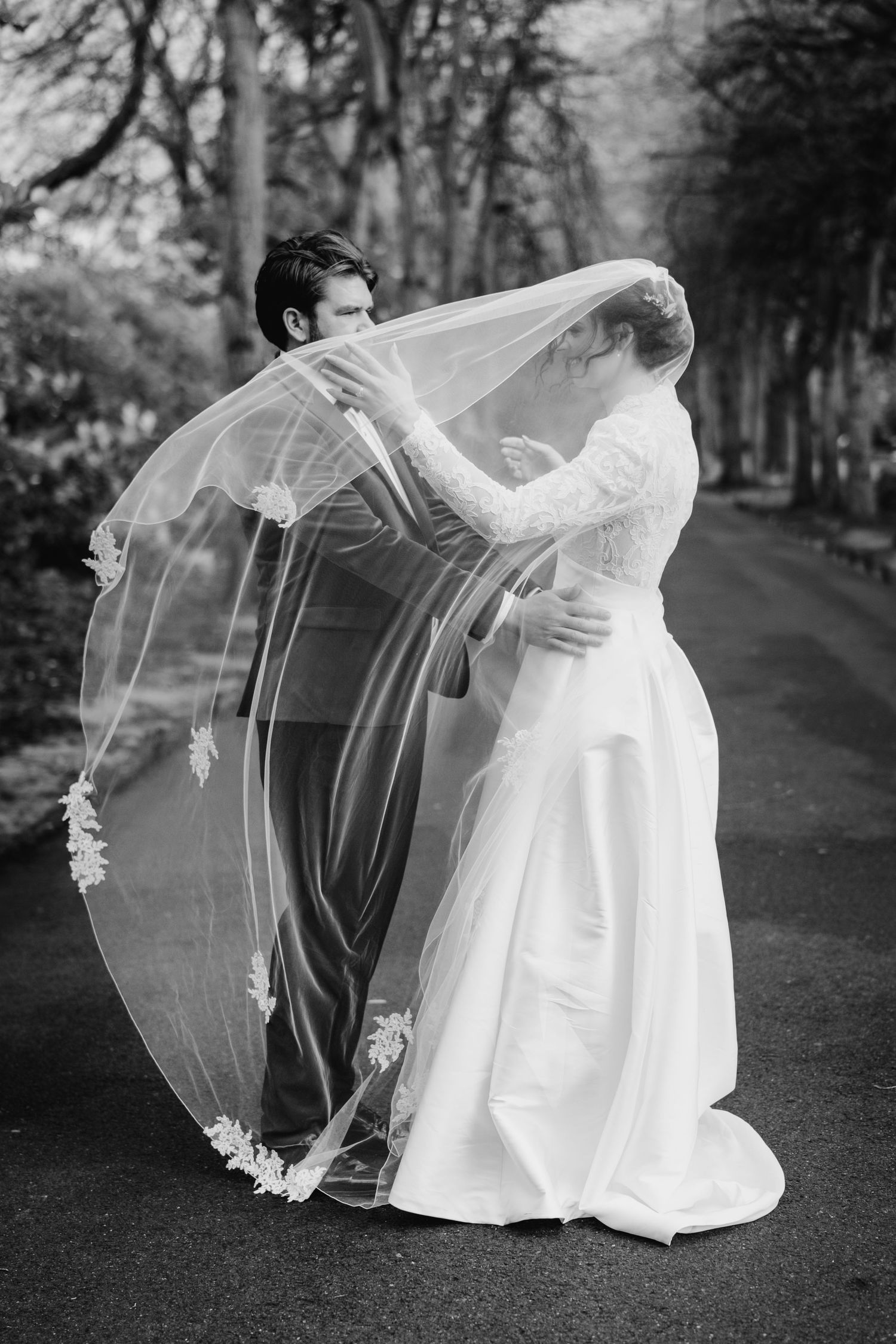 A flowing white wedding dress veil billows dramatically in black and white photos outdoors. Stephens green club dublin Wedding photographer