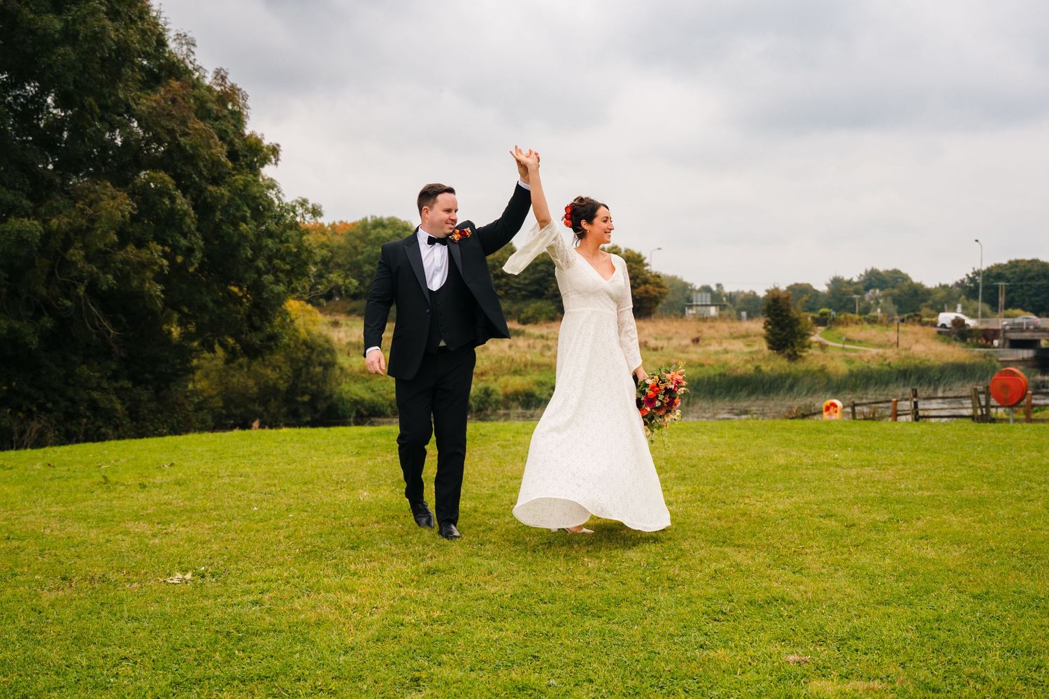 Wedding couple enjoying a joyful moment while running across a grassy hillside.Wedding Photography Trim Castle Ireland