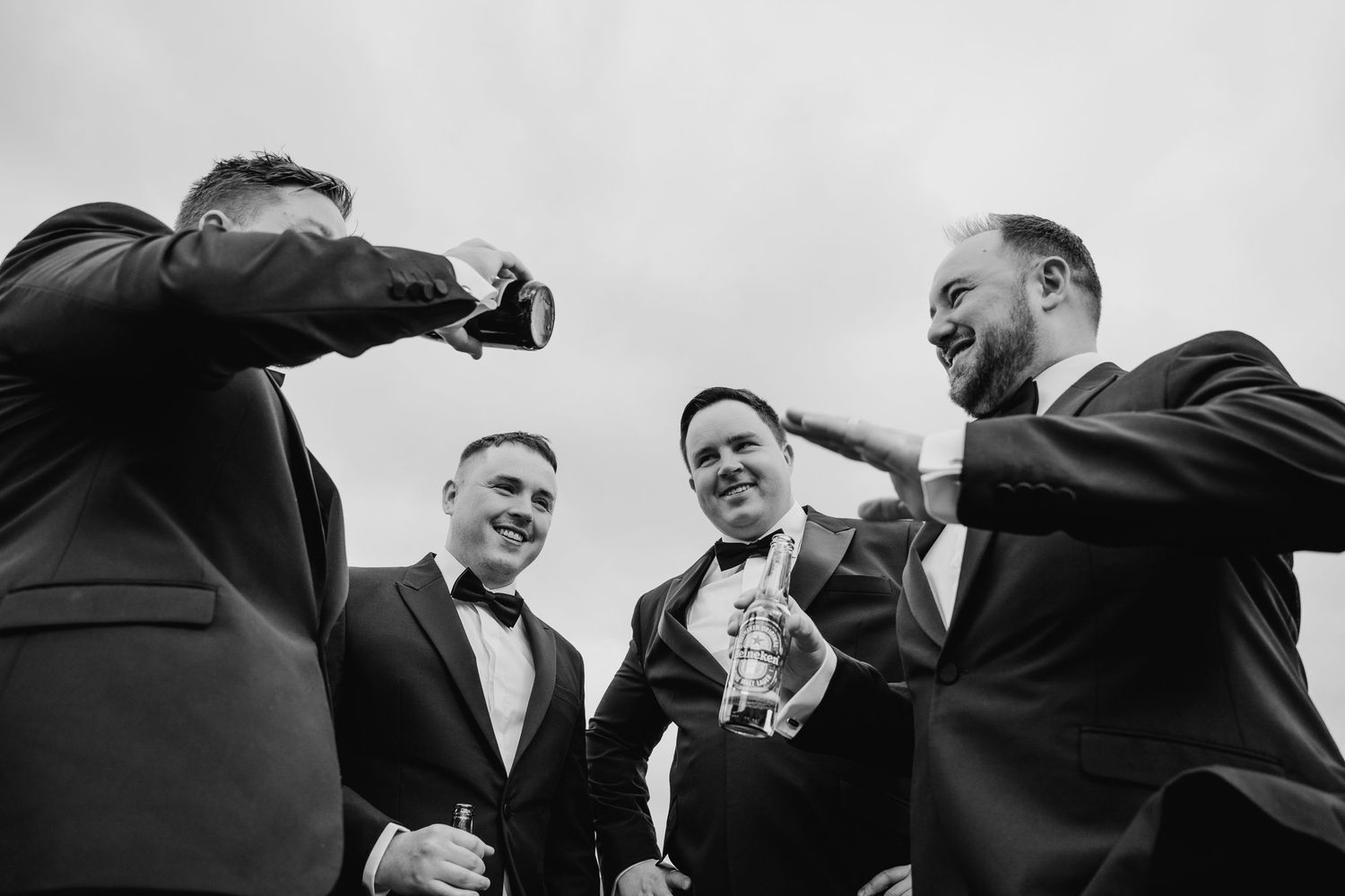 Black and white photo showing groomsmen laughing and smiling together outdoors. Wedding Photography Trim Castle Ireland