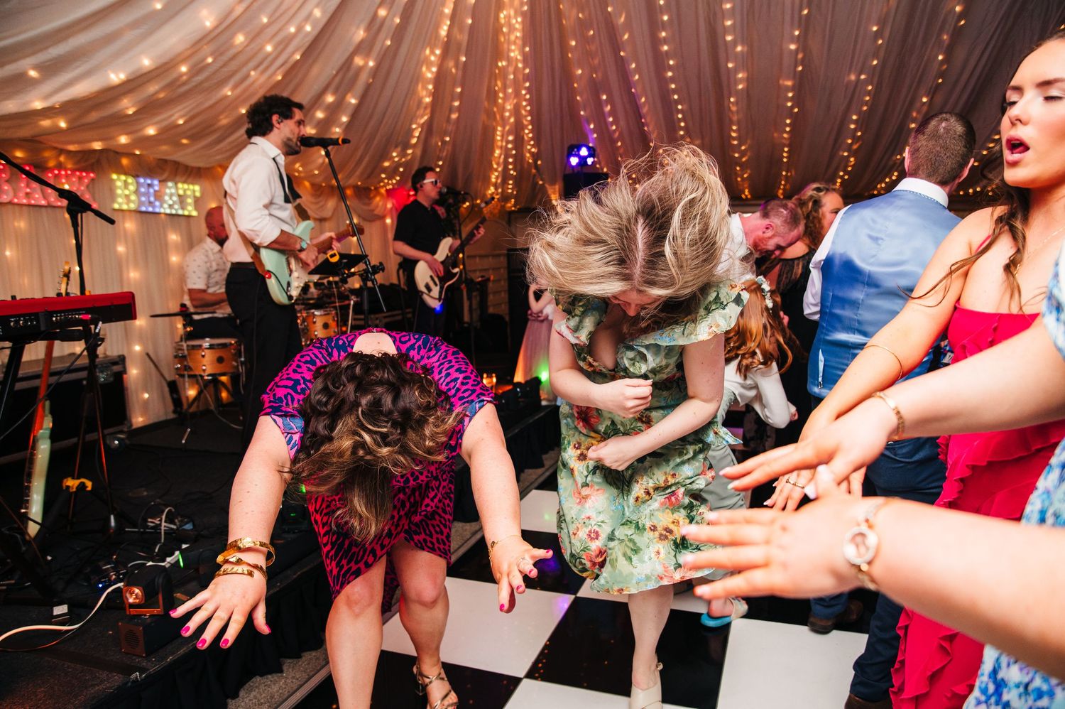 Castle Leslie Wedding PhDancers enjoying a lively wedding reception with string lights and decorative elements overhead on the dance floor.