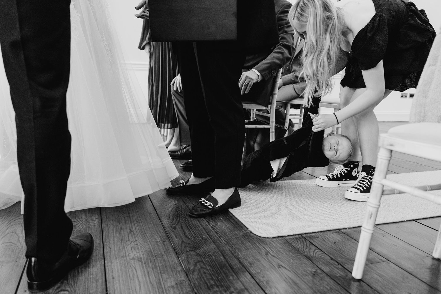 Black and white detail shot of feet and shoes on a wooden floor during a wedding preparation.  Wedding PHOTOGRAPHER Dublin