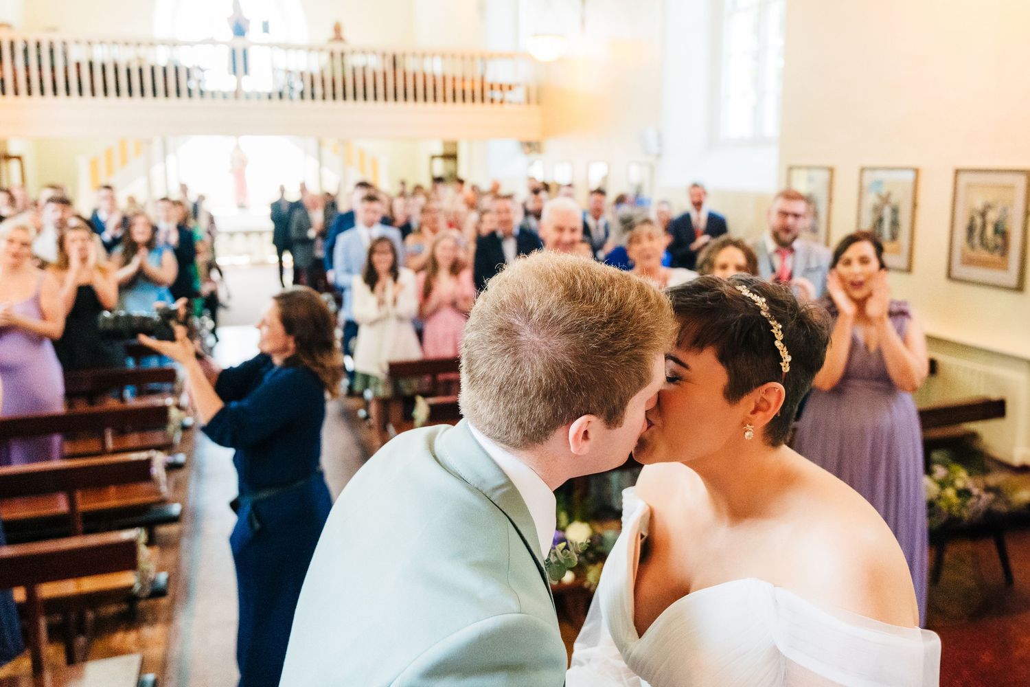 Millhouse slane wedding photographer dublin Romantic celebration moment in an elegant church interior with guests watching.