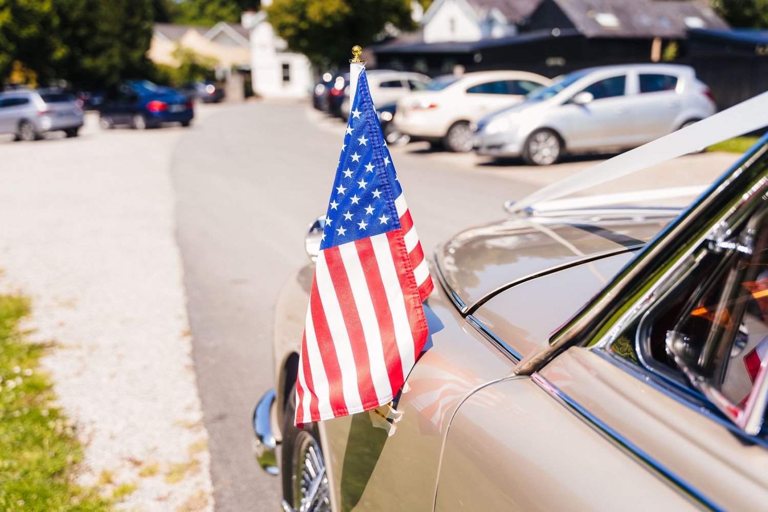 Poulaphouca Wedding photographer wicklow  American flag mounted on vintage car exterior during daytime event.