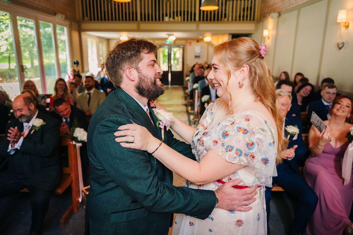 Joyful dance floor scenes from a wedding reception celebration with guests dancing and embracing. . Village Barn Tyrrellspass wedding photog