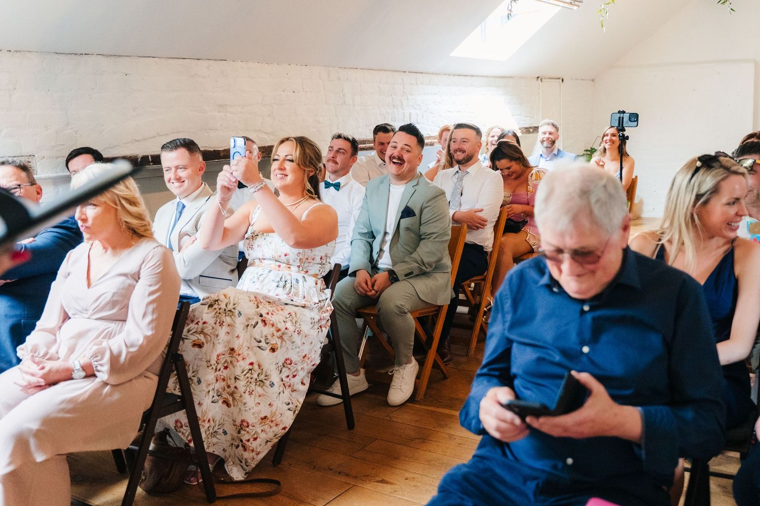 Wedding guests seated in rows at an indoor ceremony venue. Same sex wedding PHOTOGRAPHER Dublin
