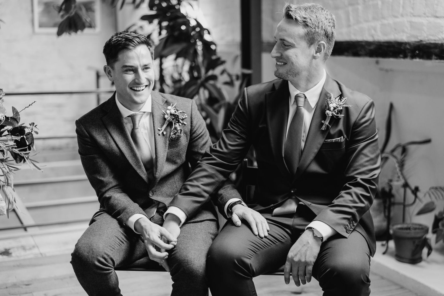 Wedding party sharing intimate conversations and laughs in black and white. Same sex wedding PHOTOGRAPHER Dublin