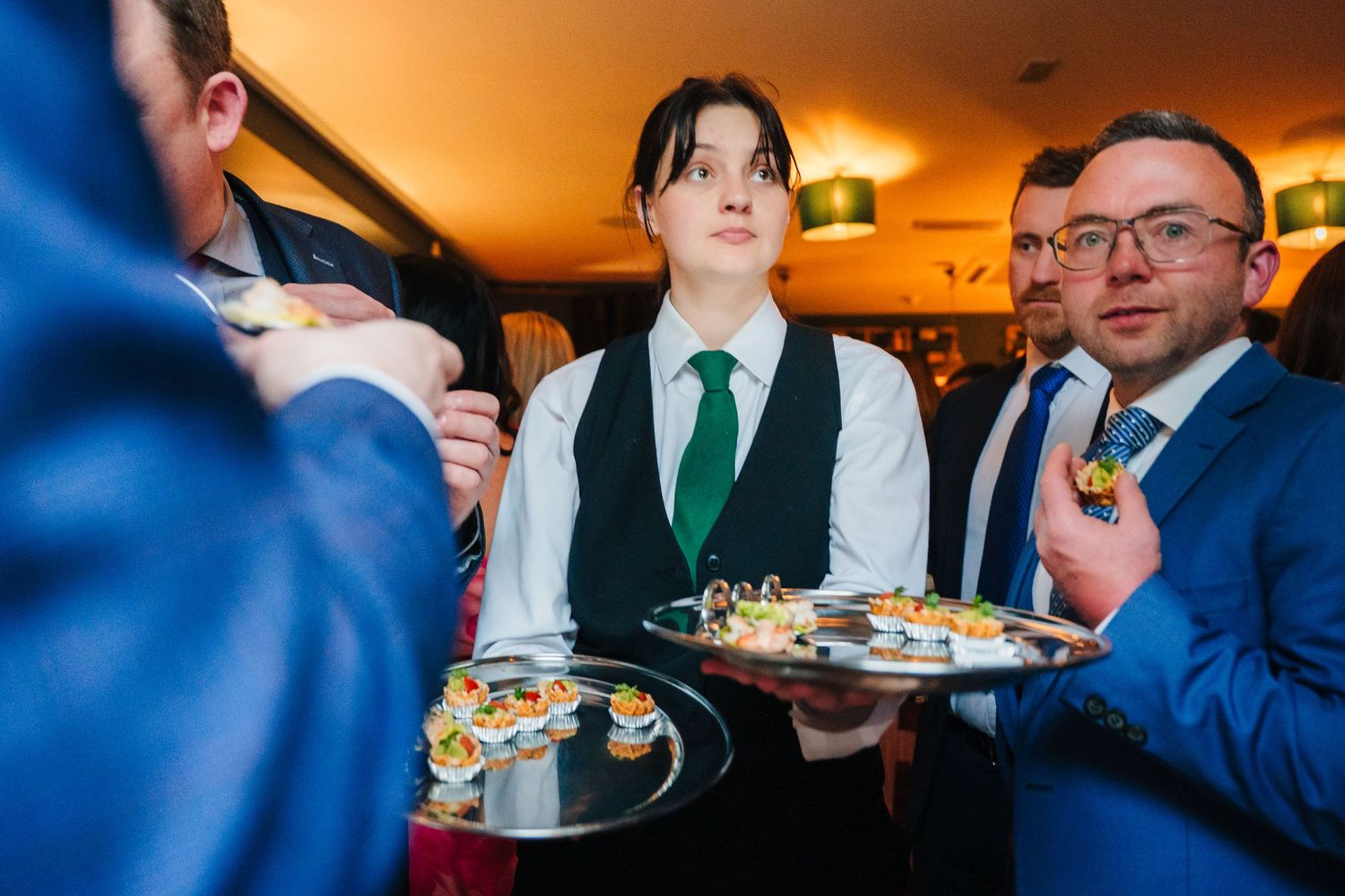 Server carrying appetizer plates at an indoor event. Marco Pierre Dublin Wedding Photographer
