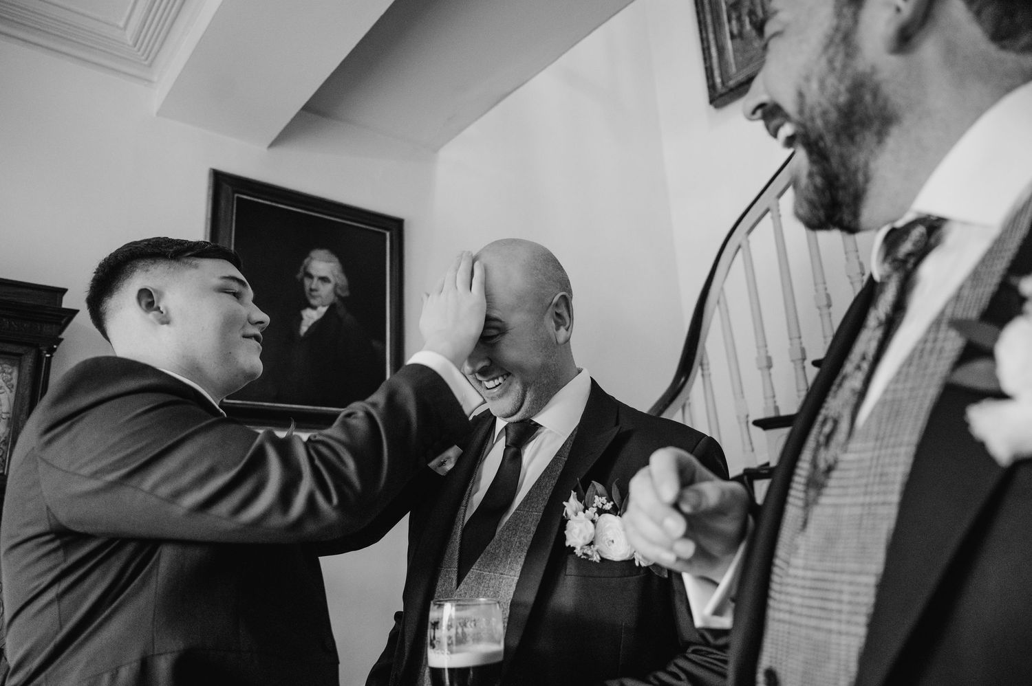 A series of black and white photographs mounted on a wall showing people in formal attire at an event. Virginia Park Lodge Wedding Photograp