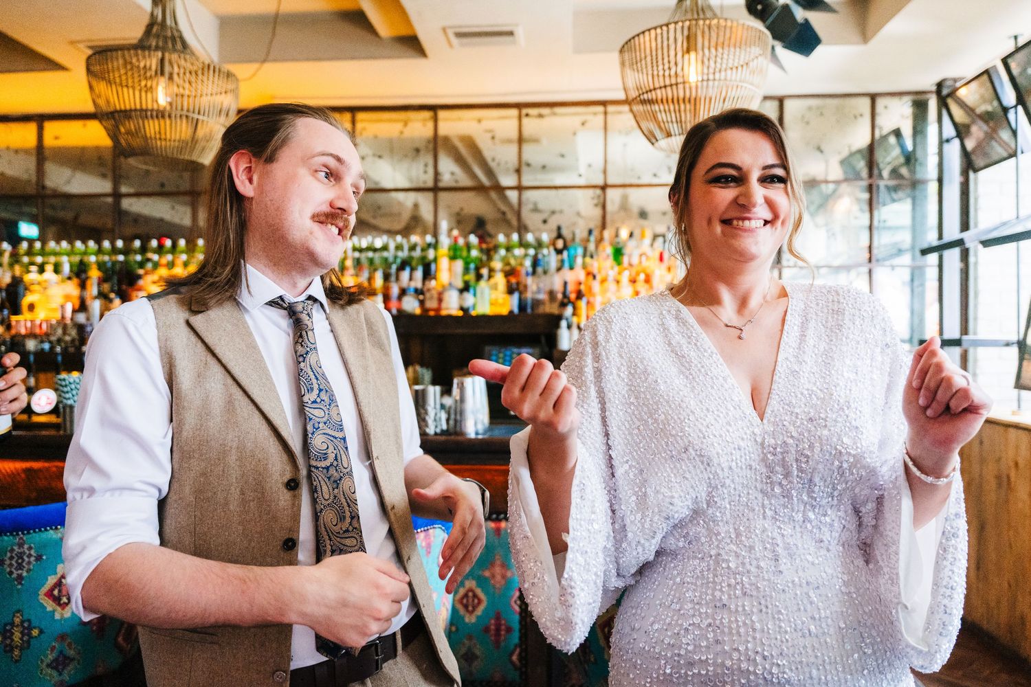 Two people share a candid laughing moment in a restaurant with warm lighting and decorative fixtures. House Dublin Wedding Photographer