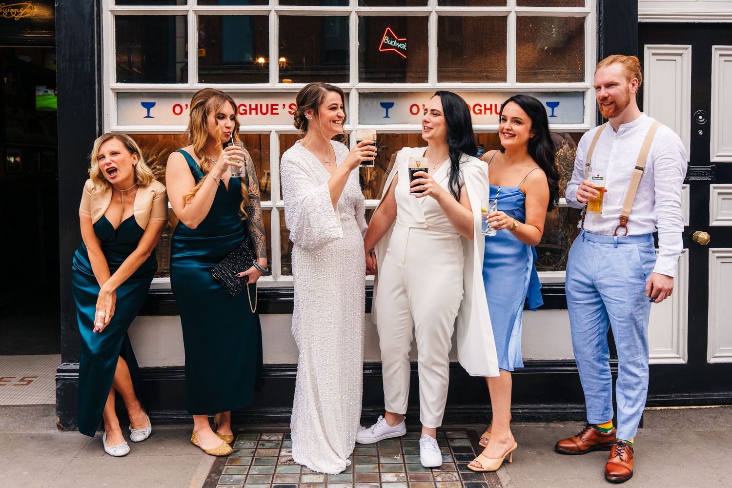 A celebratory group shot of friends enjoying drinks outside a building. House Dublin Wedding Photographer