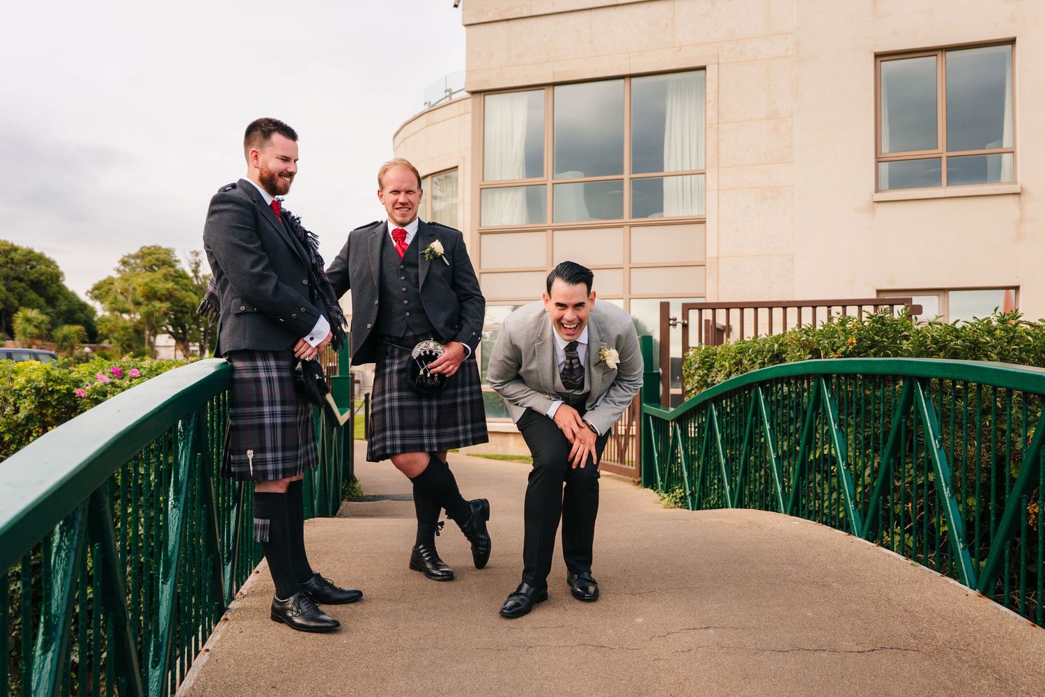 Wedding party members relaxing on outdoor terrace with modern architecture. Portmarnock Hotel Wedding PHOTOGRAPHER Dublin