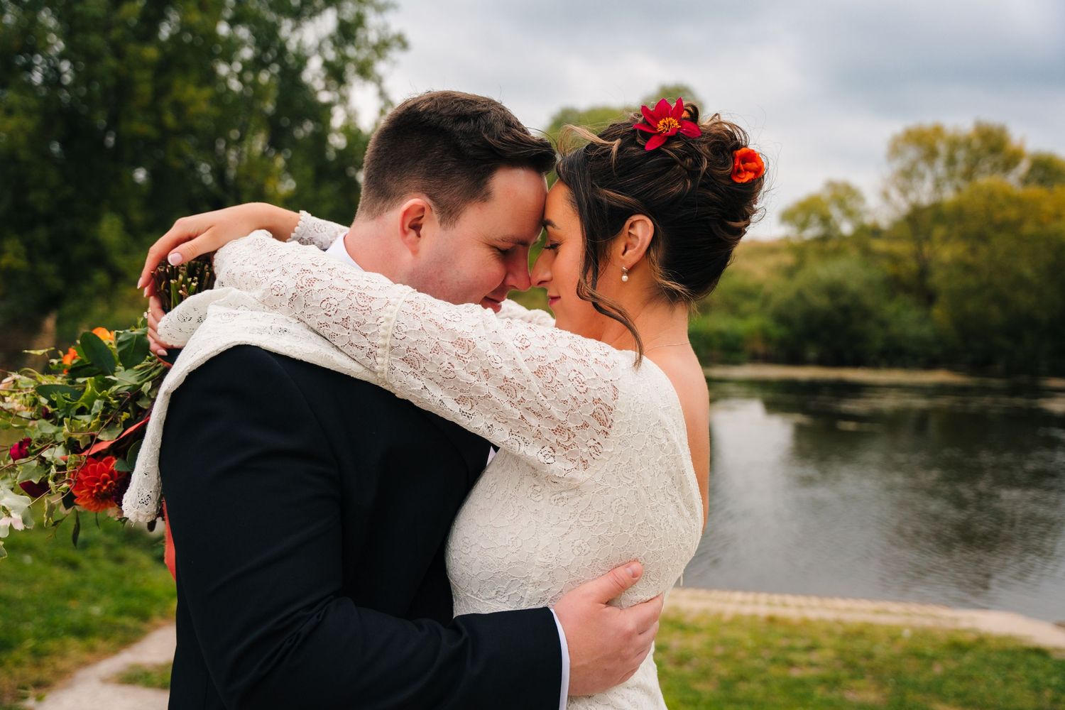 A romantic embrace between newlyweds near a pond on an autumn day. Wedding Photography Trim Castle Ireland