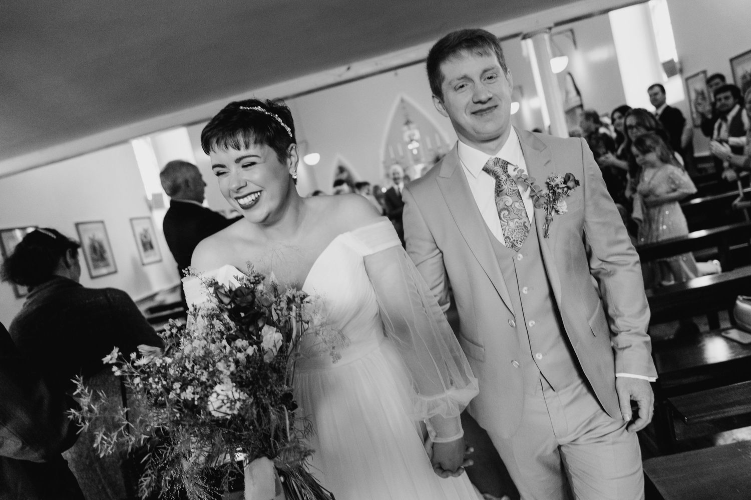 A black and white wedding ceremony photo showing a couple walking down the aisle in traditional attire.Millhouse slane wedding photographer