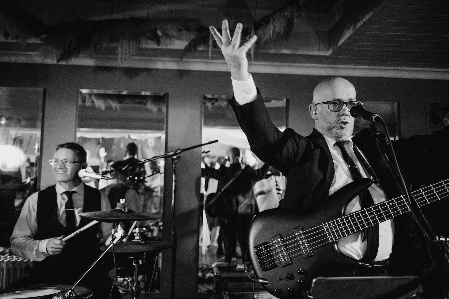 Millhouse slane wedding photographer dublin Wedding band musicians perform with bass player raising hand during reception performance.