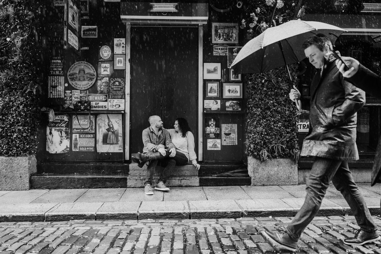 Black and white photo series showing silhouettes of people walking past urban storefronts. Proposal Dublin Photographer