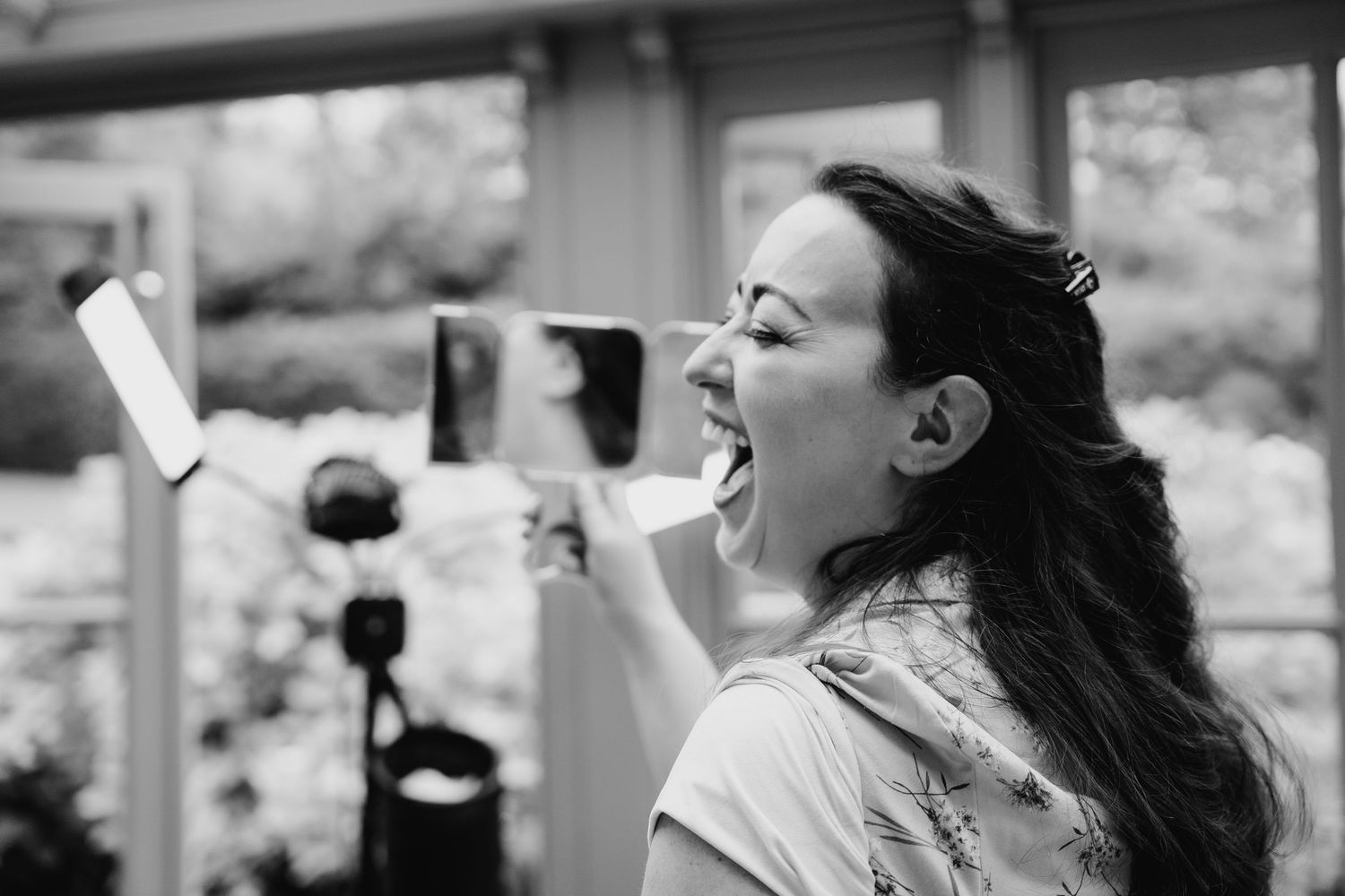 A joyful moment captured in black and white as someone laughs expressively with their head tilted back outdoors. Wedding photographer Dublin