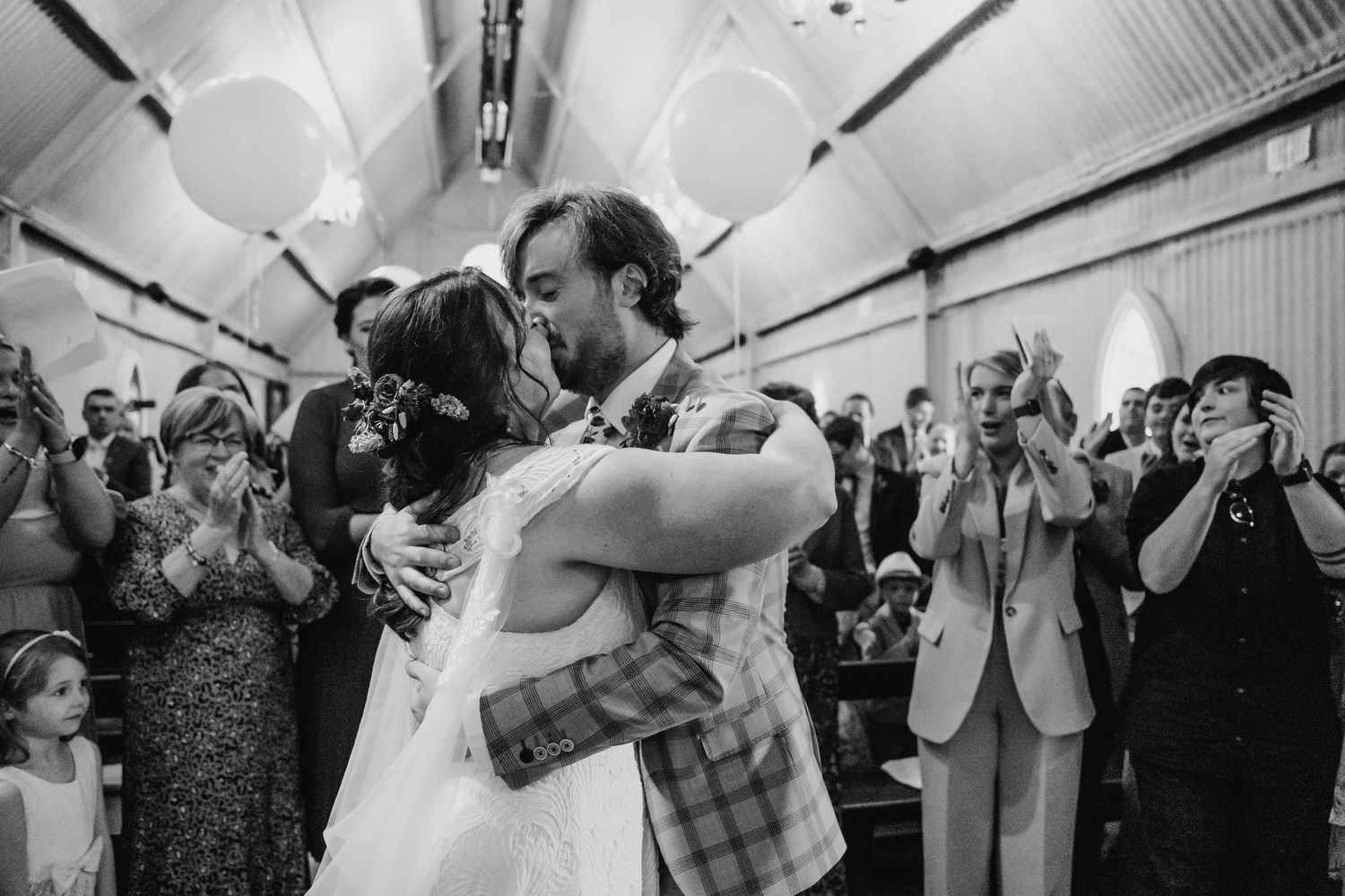 Joyful wedding reception moments captured in black and white under a decorated tent ceiling. Wedding photographer Dublin