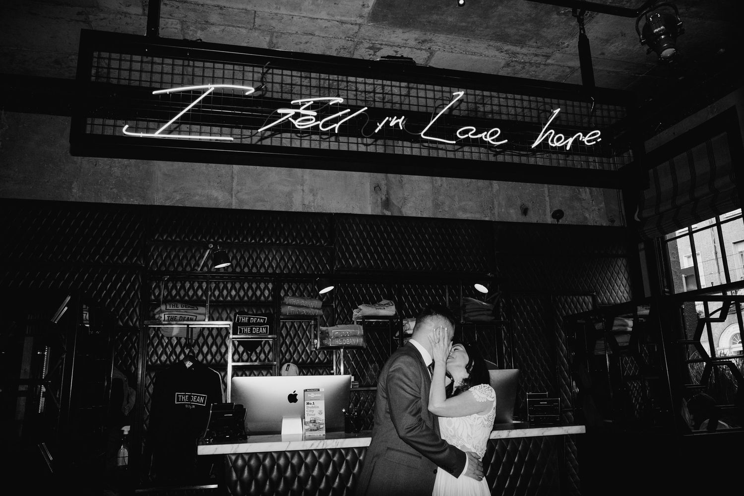 Silhouetted figures dance in a dark indoor venue with moody lighting and architectural details visible. Wedding PHOTOGRAPHER Dublin
