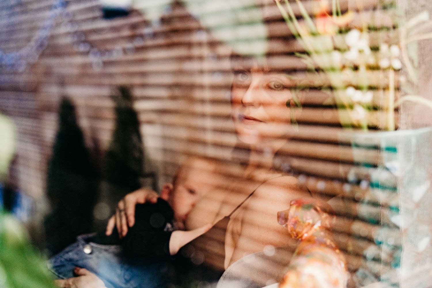 Dreamy window view through wooden blinds with soft bokeh light effects creating a warm atmosphere. family PHOTOGRAPHER Dublin